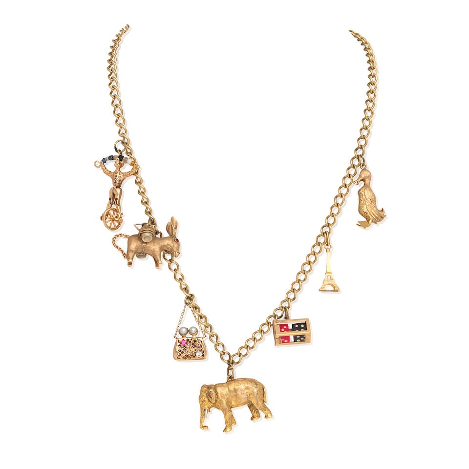 CHARM NECKLACE: CHARM NECKLACE Suspending seven charms, including an elephant, hinged bag and two dice in box UK hallmarks Length 60.0cm Weight approx. 51.0g Footnotes: OVERALL CONDITION Curb-links stamped 375.