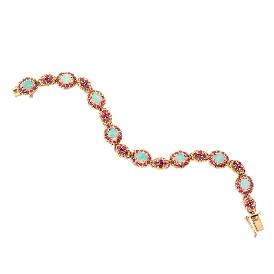 OPAL AND RUBY CLUSTER BRACELET: OPAL AND RUBY CLUSTER BRACELET Opal cabochons Circular-cut rubies Length 18.0cm Weight approx. 15.5g Footnotes: OVERALL CONDITION Some surface wear to unhallmarked metal stamped with 18K.