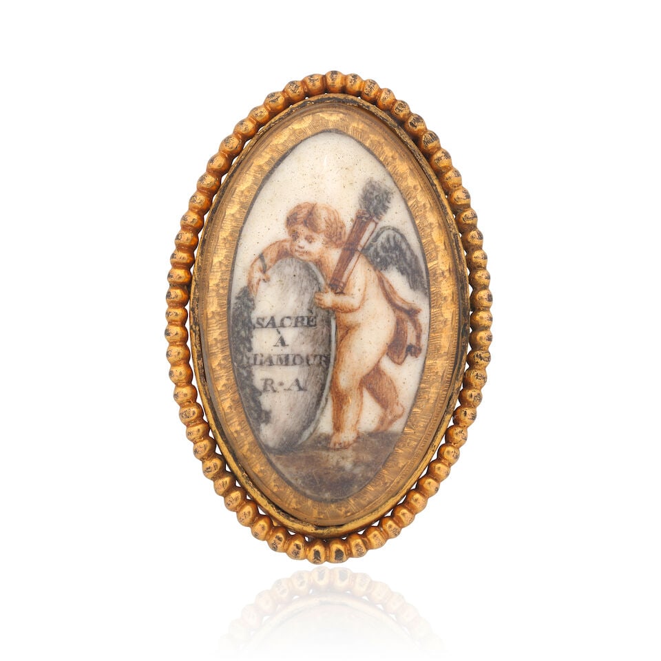 IVORY MOURNING BROOCH, CIRCA 1790: IVORY MOURNING BROOCH, CIRCA 1790 Navette-shaped ivory plaque Painted in sepia watercolour to depict Cupid and a headstone engraved, SACRÈ À L'AMOUR R.A. ('Sacred to Love' or 'Hallowed be lo