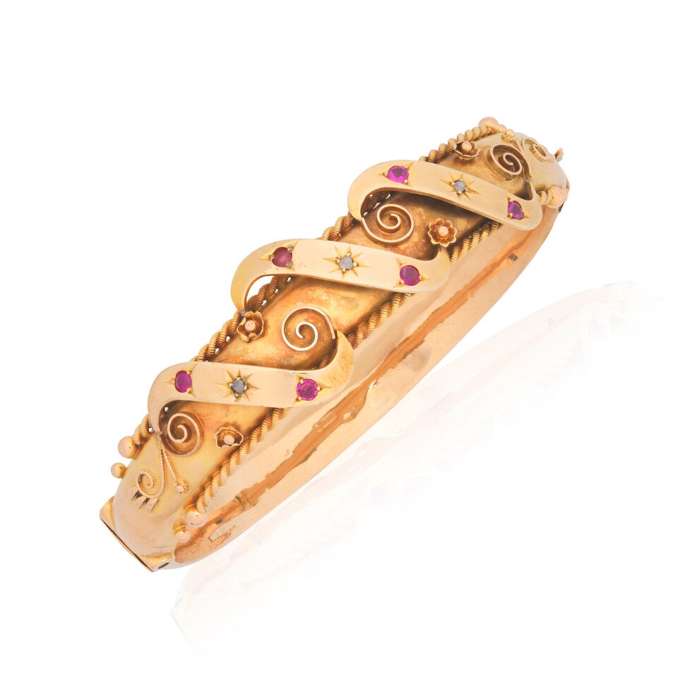 GEM-SET HINGED BANGLE, 1909: GEM-SET HINGED BANGLE, 1909 Circular-cut rubies Rose-cut diamonds 9 carat gold UK hallmark Inner circumference approx. 17.5cm Weight approx. 14.5g Cased Footnotes: OVERALL CONDITION Some wear to 9