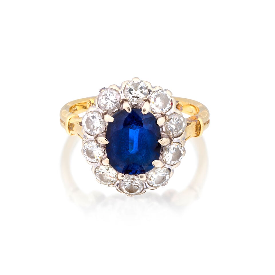 SAPPHIRE AND DIAMOND CLUSTER RING, 1973: SAPPHIRE AND DIAMOND CLUSTER RING, 1973 Cushion-cut sapphire Brilliant-cut diamonds approx. 1.40cts total 18 carat gold London hallmark Ring size approx. P½ Weight approx.