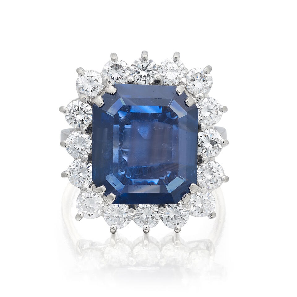 SAPPHIRE AND DIAMOND CLUSTER RING: SAPPHIRE AND DIAMOND CLUSTER RING Octagonal step-cut sapphire, very approx. 14.30cts Brilliant-cut diamonds, approx. 1.85cts total 18 carat white gold UK hallmarks Ring size approx. J (sizing