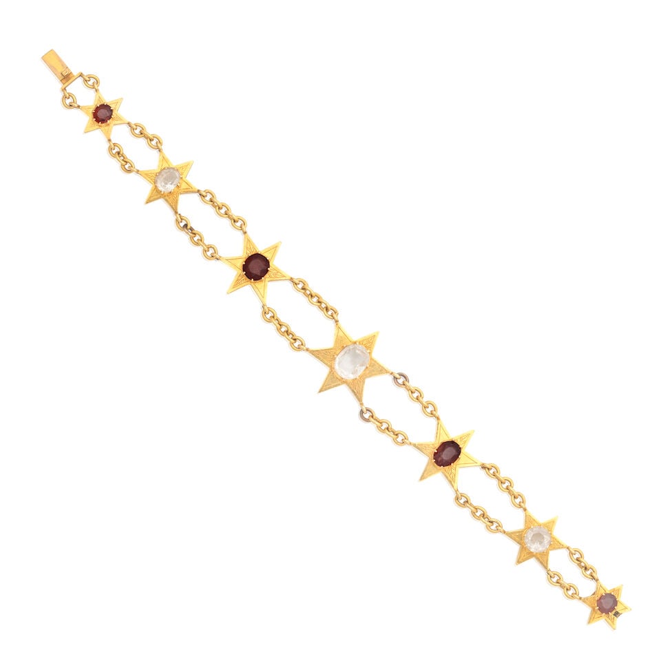 GEM-SET STAR BRACELET: GEM-SET STAR BRACELET Oval and circular-cut rock crystal Oval and circular-cut garnets Length 18.0cm Weight approx. 22.0g Footnotes: OVERALL CONDITION Some light surface wear to unhallmarked yellow me