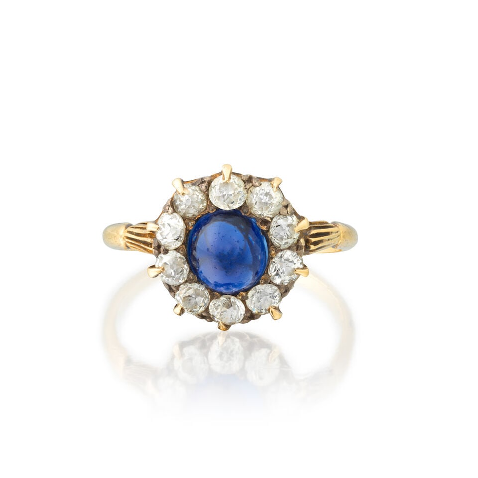SAPPHIRE AND DIAMOND CLUSTER RING: SAPPHIRE AND DIAMOND CLUSTER RING Sapphire cabochon Old brilliant-cut diamonds approx. 0.70ct total Mounted in gold Ring size approx. N Weight approx. 3.0g Footnotes: GCS: Natural sapphire of Burmese