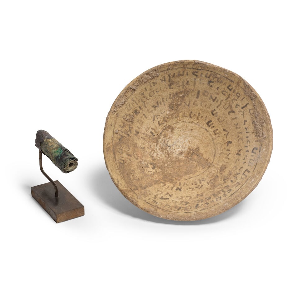 Un bol incantatoire mésopotamien en terre cuite et un rouleau irakien en bronze, Ca. IIIe-V...: Un bol incantatoire mésopotamien en terre cuite et un rouleau irakien en bronze, Ca. IIIe-VIIe siècle ap. J.C. A Mesopotamian pottery incantation bowl and Iraqi bronze scroll, circa 3rd-7th