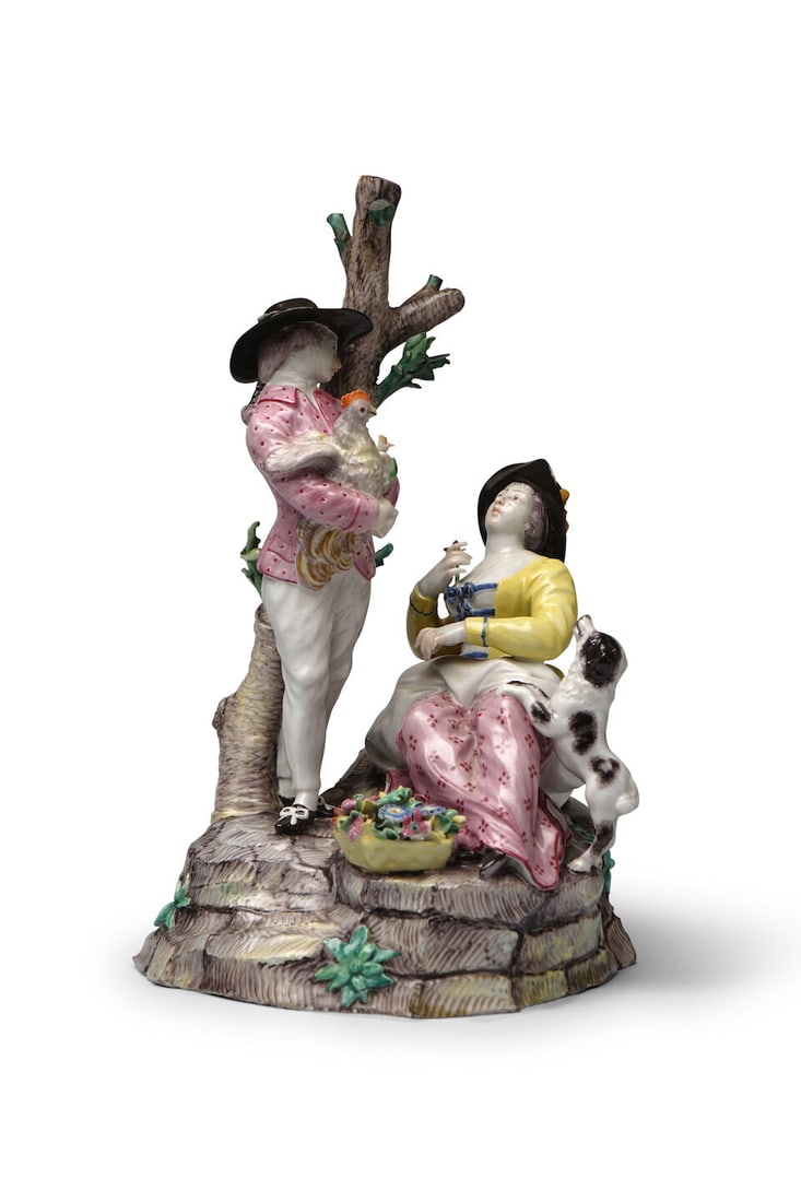 Groupe pastoral en porcelaine de Doccia, vers 1780-90 A Doccia pastoral group, circa 1780-90: Groupe pastoral en porcelaine de Doccia, vers 1780-90 A Doccia pastoral group, circa 1780-90 A boy holding a chicken and recumbent woman with a dog jumping at her knees and a basket of flowers at