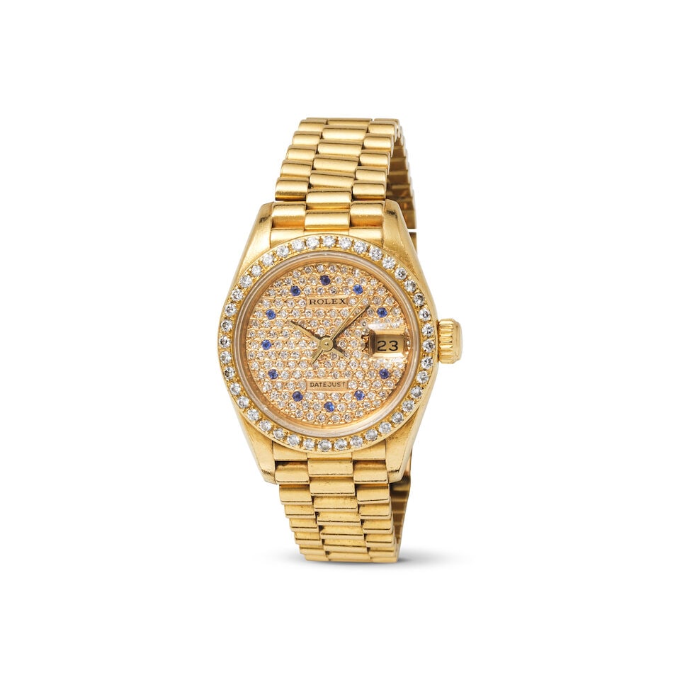 Rolex. A lady's 18K gold automatic calendar bracelet watch with diamond and sapphire set dial an... (1 of 1)