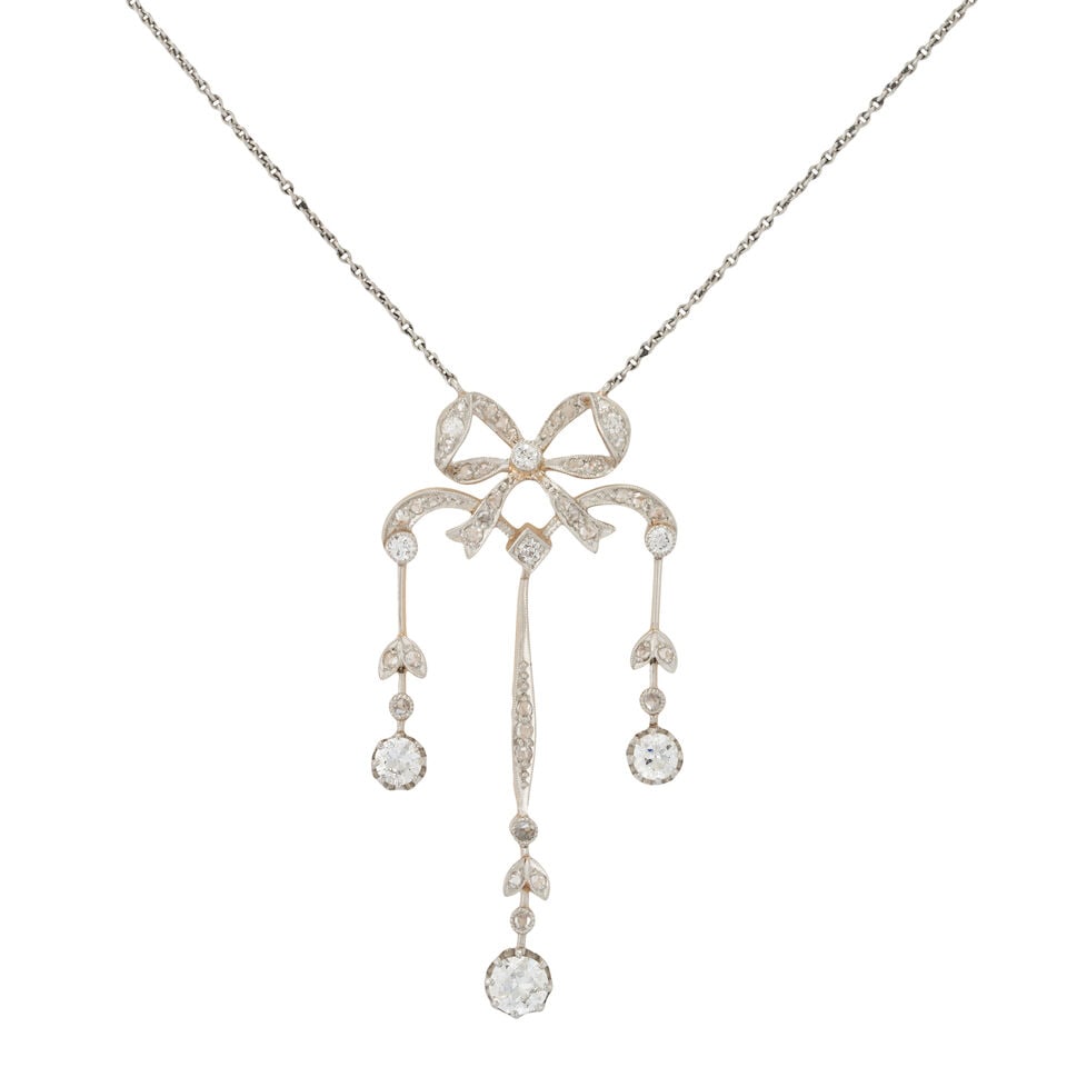 AN EDWARDIAN PENDANT NECKLACE: AN EDWARDIAN PENDANT NECKLACE The pendant designed as a bow suspending old-European-cut diamond drops, set throughout with old European, old single, and rose-cut diamonds, approximate total weight