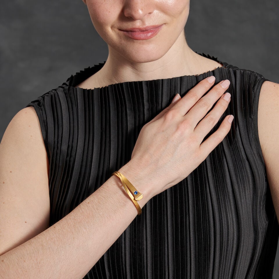 L. FRITZSCHE & CO.: AN ANTIQUE 14K GOLD AND SYNTHETIC SPINEL BANGLE BRACELET: L. FRITZSCHE & CO.: AN ANTIQUE 14K GOLD AND SYNTHETIC SPINEL BANGLE BRACELET The hinged bangle designed as a nail, with bezel-set synthetic spinel, weight 9.1 dwt, maker's mark for L. Fritzsche &