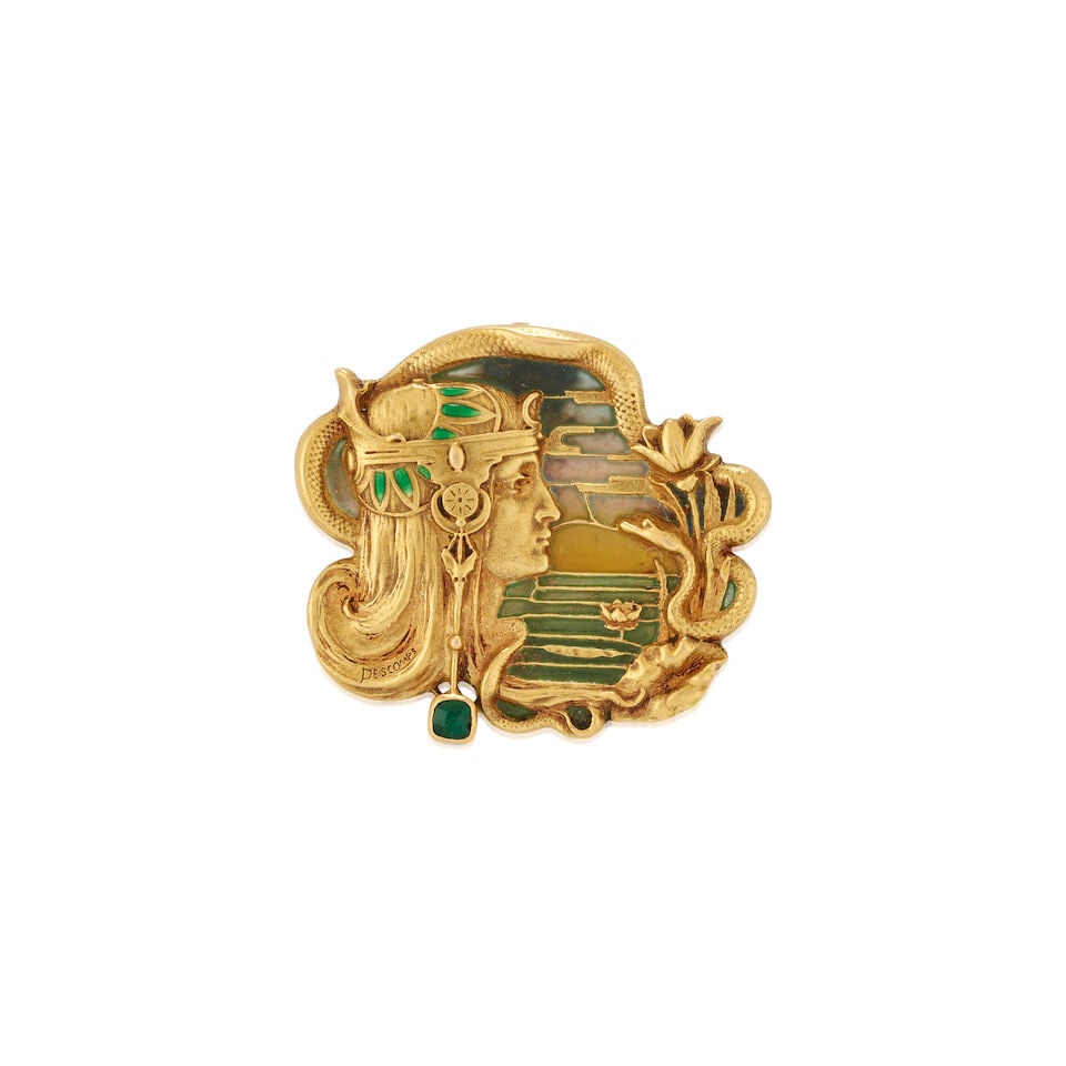 JOÉ DESCOMPS: AN ART NOUVEAU 18K GOLD, PLIQUE-A-JOUR ENAMEL, AND EMERALD BROOCH, FRANCE: JOÉ DESCOMPS: AN ART NOUVEAU 18K GOLD, PLIQUE-A-JOUR ENAMEL, AND EMERALD BROOCH, FRANCE Depicting a Mucha-style figure adorned with headdress, with bezel-set fancy-cut emerald accent, within a pl