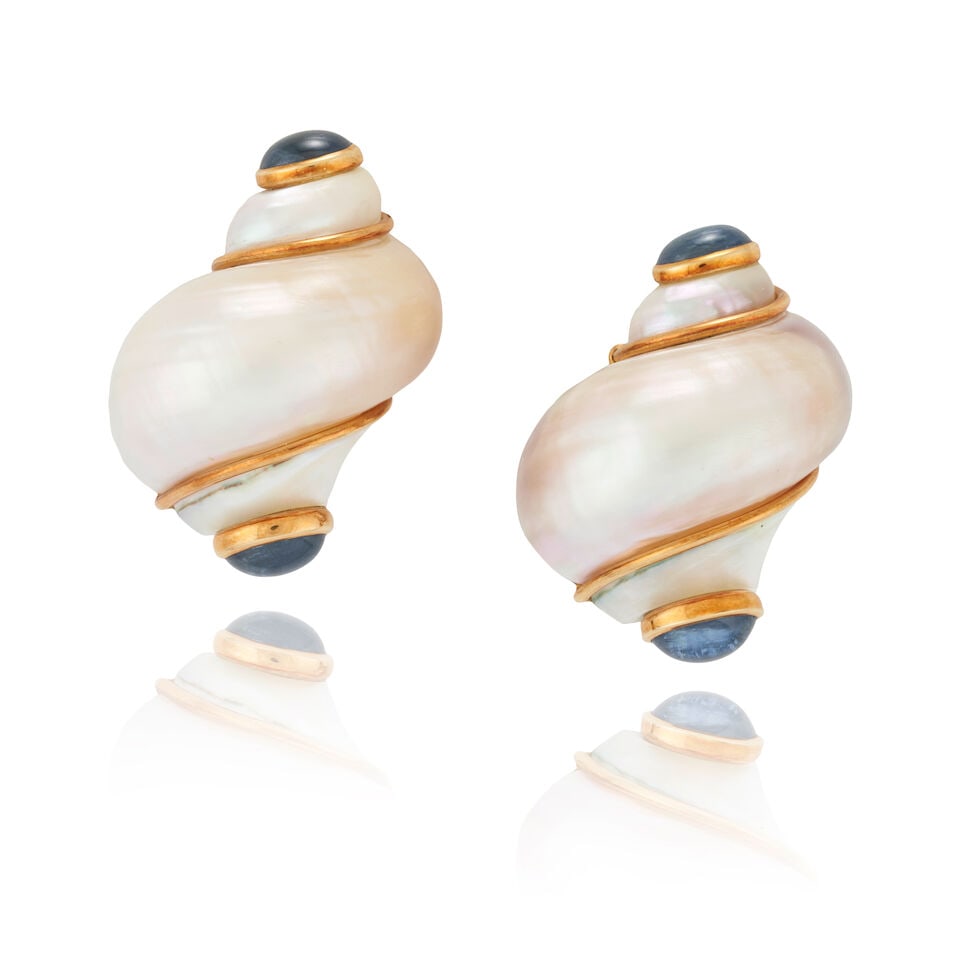 SEAMAN SCHEPPS: A PAIR OF 18K GOLD, SAPPHIRE, AND SHELL EARCLIPS: SEAMAN SCHEPPS: A PAIR OF 18K GOLD, SAPPHIRE, AND SHELL EARCLIPS The turbo shells each with bezel-set oval cabochon sapphire terminals, weight 21.1 dwt, signed Seaman Schepps, maker's mark for