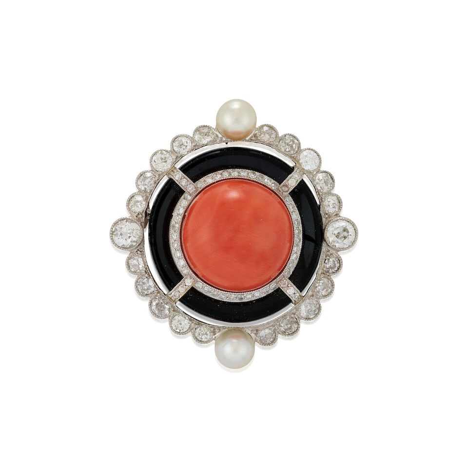 A CORAL, ONYX, PEARL, AND DIAMOND BROOCH: A CORAL, ONYX, PEARL, AND DIAMOND BROOCH Centering a large coral double cabochon measuring approximately 16.10 x 11.00 mm, bordered by rows of single-cut diamonds, a carved onyx ring, and an old