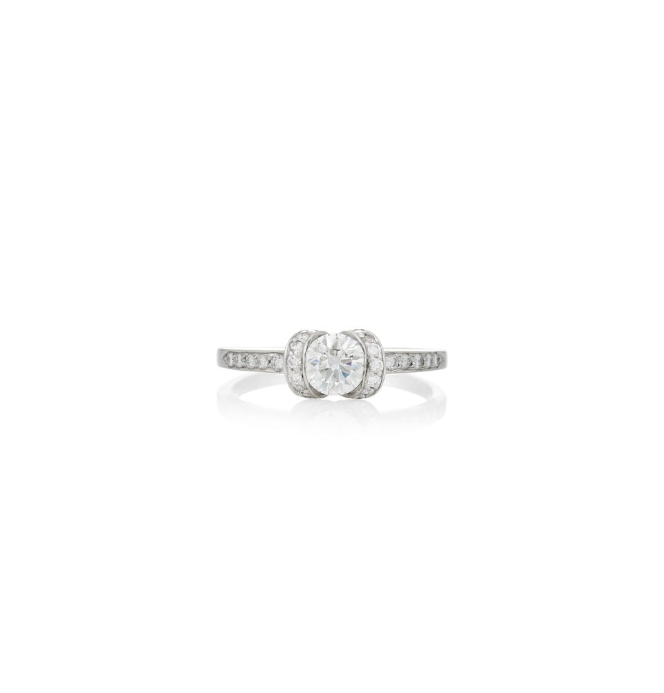 TIFFANY & CO.: A PLATINUM AND DIAMOND 'RIBBON' RING: TIFFANY & CO.: A PLATINUM AND DIAMOND 'RIBBON' RING Centering a full-cut diamond, weighing 0.71 carats, framed by full-cut diamonds, weight 3.2 dwt, signed Tiffany & Co., numbered, between size 8