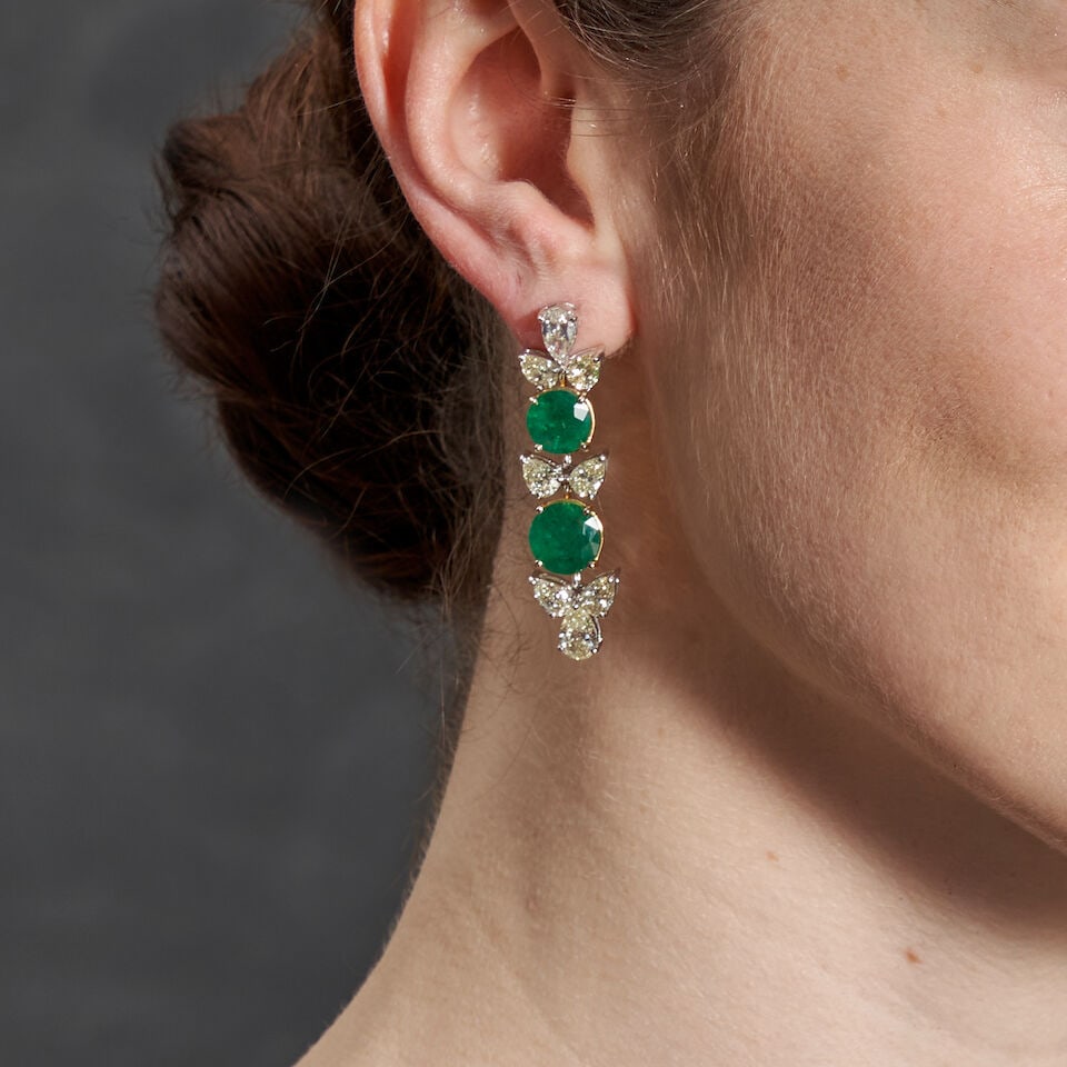 A PAIR OF 18K BI-COLOR GOLD, EMERALD, AND DIAMOND EARRINGS: A PAIR OF 18K BI-COLOR GOLD, EMERALD, AND DIAMOND EARRINGS Set with circular-cut emeralds, total weight 11.62 carats, and pear shape diamonds, total weight 7.29 carats, weight 12.1 dwt, length 1 7/8
