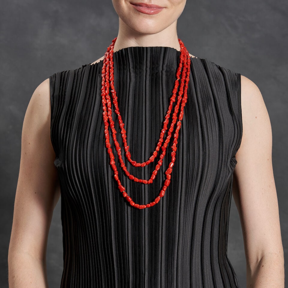 A CORAL BEAD NECKLACE: A CORAL BEAD NECKLACE The long necklace composed of organic-shaped coral beads, with gold spacers, length 95 in. Footnotes: Please note this item cannot be shipped internationally as it may contain