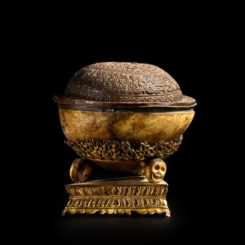 A BONE KAPALA WITH COPPER COVER AND GILT COPPER ALLOY STAND TIBET, 19TH CENTURY: A BONE KAPALA WITH COPPER COVER AND GILT COPPER ALLOY STAND TIBET, 19TH CENTURY Himalayan Art Resources item no. 8804 7 in. (17.8 cm) high Footnotes: 西藏