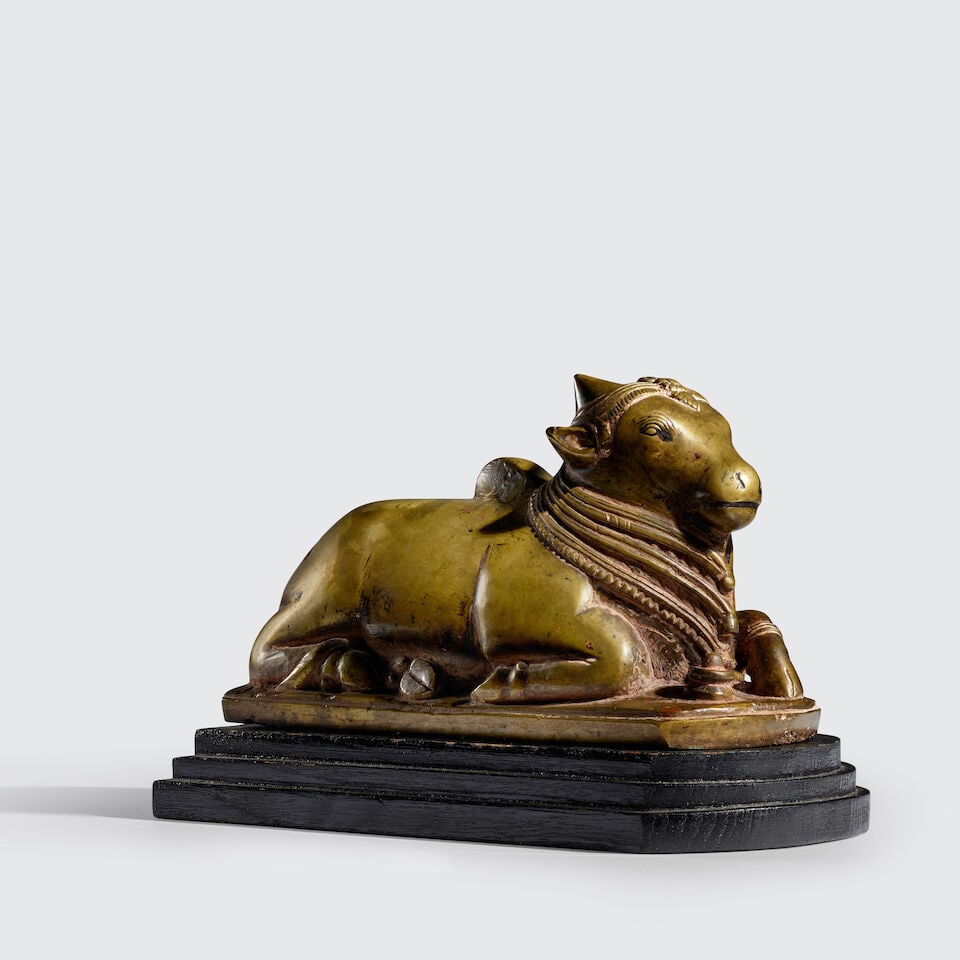 A BRASS FIGURE OF NANDI SOUTHERN INDIA, KARNATAKA OR TAMIL NADU, 17TH/18TH CENTURY: A BRASS FIGURE OF NANDI SOUTHERN INDIA, KARNATAKA OR TAMIL NADU, 17TH/18TH CENTURY 5 1/4 in. (13.3 cm) high; 8 3/8 in. (21.3 cm) long Footnotes: Provenance Private Virginia Collection since late 1990