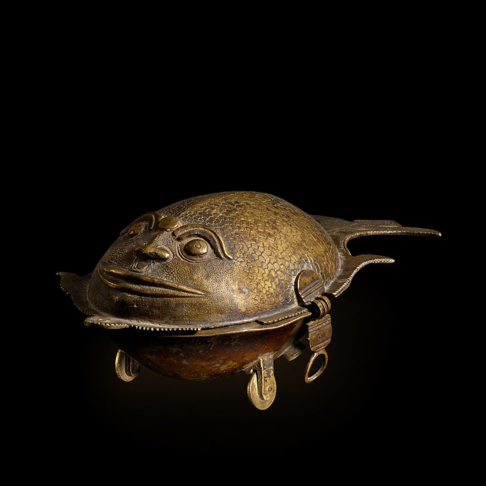 A BRASS PANDAN BOX IN THE SHAPE OF A FISH CENTRAL INDIA, 19TH CENTURY: A BRASS PANDAN BOX IN THE SHAPE OF A FISH CENTRAL INDIA, 19TH CENTURY 10 1/4 in. (26 cm) long Footnotes: Provenance Santa Fe art market, c. 2022 This fish-shaped box with wheels and a hinged lid conta
