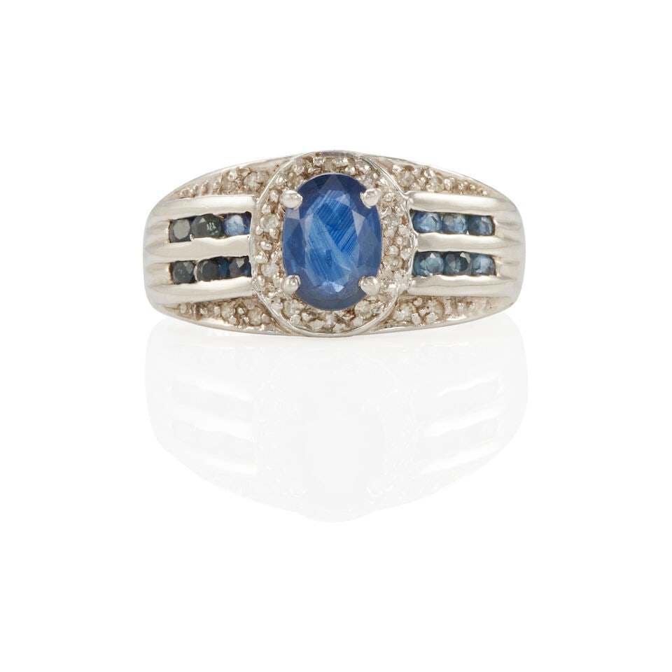 PLATINUM, SAPPHIRE, AND DIAMOND RING: PLATINUM, SAPPHIRE, AND DIAMOND RING • Platinum • 1 oval and 12 round sapphires weighing approximately 0.95 - 1.00 carats total • 18 round single diamonds, weighing approximately