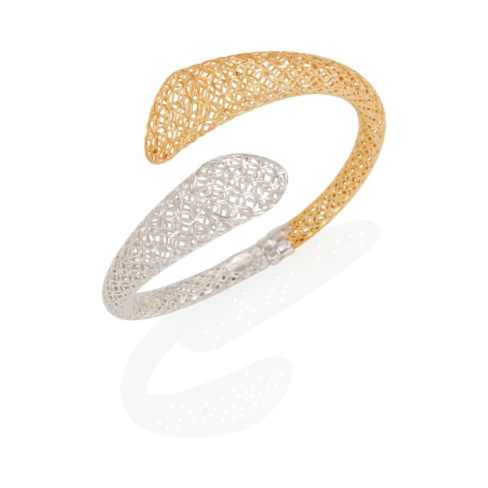 A 14K BI-COLOR GOLD BRACELET: A 14K BI-COLOR GOLD BRACELET A hinged bangle, of bypass white and yellow gold design, Italy, inner circumference 6 3/4 in. Footnotes: OVERALL CONDITION: Metal stamped and tested with XRF (X-ray