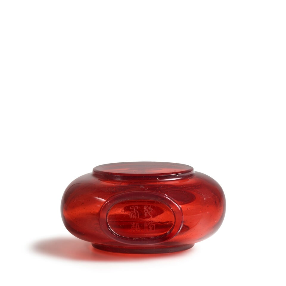 AN IMPERIAL ROUNDED TRANSPARENT RED GLASS MOLDED PANEL SNUFF BOTTLE Engraved Qianlong four-char... - 2