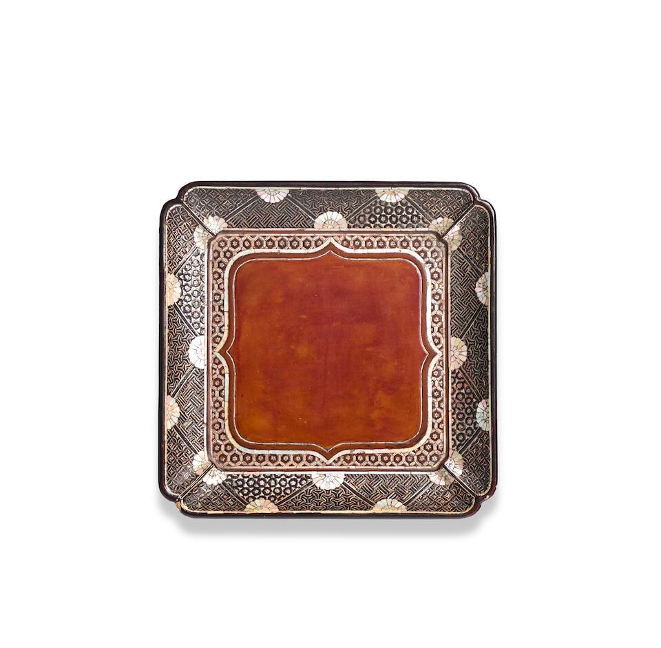 A RYUKYUAN MOTHER-OF-PEARL INLAID BROWN AND BLACK LACQUER SQUARE FOOTED TRAY Qing Dynasty/Repub...: A RYUKYUAN MOTHER-OF-PEARL INLAID BROWN AND BLACK LACQUER SQUARE FOOTED TRAY Qing Dynasty/Republic period 7 1/2in x 1 1/2in (19.5cm x 3.8cm) (Japanese wood box). Footnotes: 清/民國