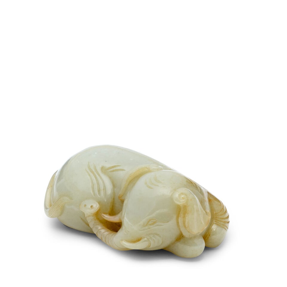 A PALE GREENISH WHITE CARVING OF AN ELEPHANT (wood stand): A PALE GREENISH WHITE CARVING OF AN ELEPHANT 3 1/4in (8.3cm) long (wood stand). Footnotes: 青白玉雕福象擺件 For further information on this lot please