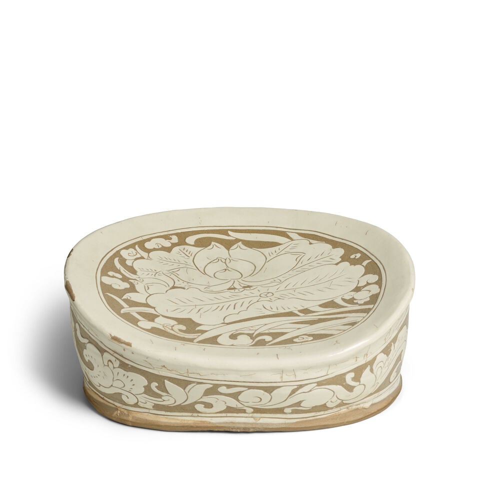 A CARVED CIZHOU 'LOTUS' BEAN-SHAPED PILLOW Song Dynasty: A CARVED CIZHOU 'LOTUS' BEAN-SHAPED PILLOW Song Dynasty 13in (33cm) across Footnotes: 宋 磁州蓮紋豆形枕 Provenance: Hayashibara Museum of Art, Japan,