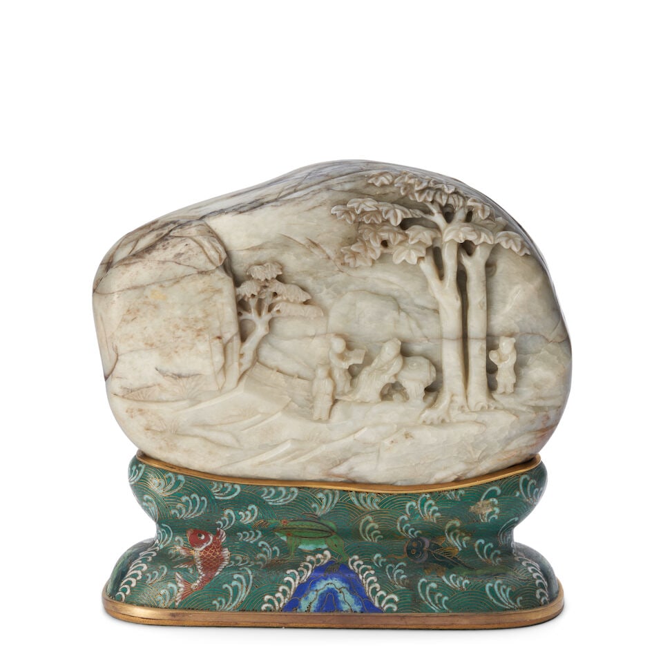 A GRAY AND WHITE JADE BOULDER ON A CLOISONNÉ ENAMEL STAND Late Qing Dynasty: A GRAY AND WHITE JADE BOULDER ON A CLOISONNÉ ENAMEL STAND Late Qing Dynasty 10 1/4 in (26cm) high, overall; 10 1/4in (26cm) across Footnotes: 清晚期 灰白玉