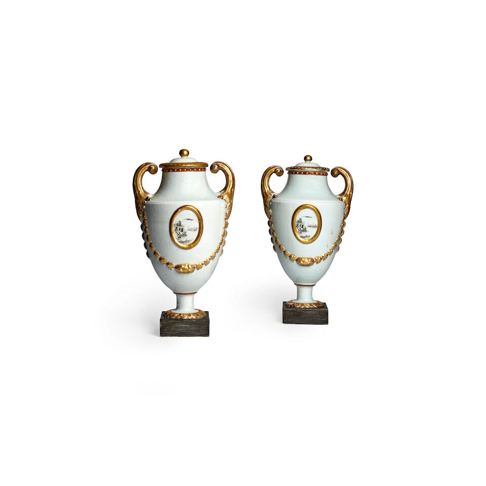A RARE PAIR OF GILT AND GRISAILLE EUROPEAN-SHAPED PISTOL-HANDLED URNS AND COVERS Late Qianlong/J...: A RARE PAIR OF GILT AND GRISAILLE EUROPEAN-SHAPED PISTOL-HANDLED URNS AND COVERS Late Qianlong/Jiaqing period, circa 1795-1810 Modeled in purely European Neo-classical style and relief molded on