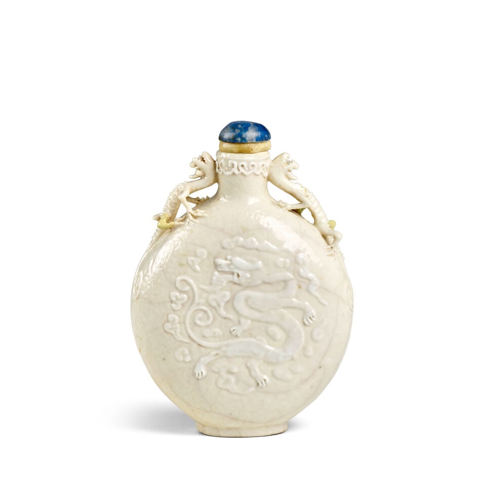 A RARE MOLDED WHITE AND CREAM-GLAZED SOFT-PASTE PORCELIAN 'COILING DRAGONS' SNUFF BOTTLE 1800-19...: A RARE MOLDED WHITE AND CREAM-GLAZED SOFT-PASTE PORCELIAN 'COILING DRAGONS' SNUFF BOTTLE 1800-1900, impressed Qianlong four-character seal mark in a line to the base 3in (7.6cm) high, stopper Footnot