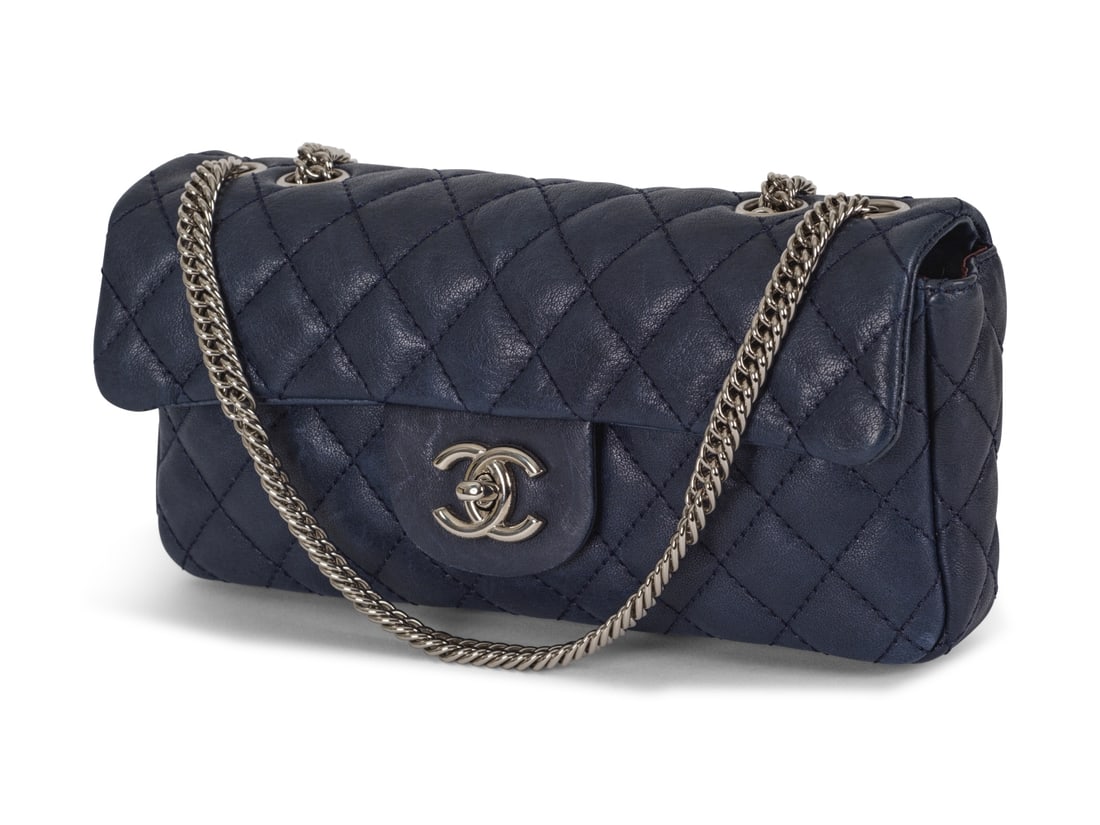 Chanel, année 2009. Sac Baguette en cuir agneau matelassé marine. Chanel, year 2009. B...: Chanel, année 2009. Sac Baguette en cuir agneau matelassé marine. Chanel, year 2009. Baguette bag in navy quilted lambskin leather. Directeur artistique: Karl Lagerfeld. Condition grade: A +