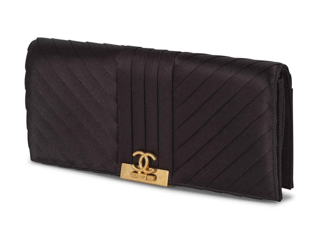 Chanel, année 2019. Pochette du soir en satin plissé noir. Chanel, 2019. Black pleated...: Chanel, année 2019. Pochette du soir en satin plissé noir. Chanel, 2019. Black pleated satin evening clutch. Directeur artistique: Karl Lagerfeld. Condition grade: A. 26 x 12 x 4 cm. Footnot