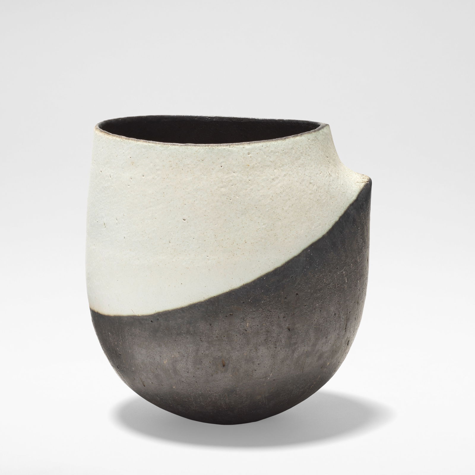 John Ward Pot, circa 1990: John Ward Pot, 1980s Stoneware, with geometric decoration in white and black glaze, of ovoid form rising to a single pinched shoulder. 21 cm high, 20 cm wide, 18 cm deep Impressed to the base with pot