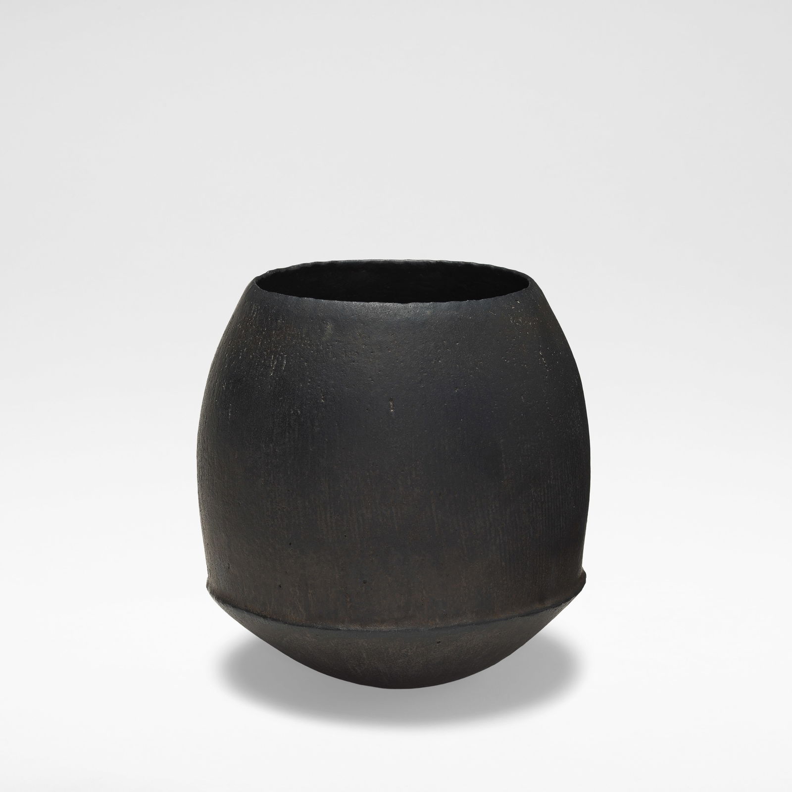 John Ward Rounded vessel, circa 1980: John Ward Rounded vessel, circa 1980 Stoneware, black textured glaze throughout, the bulbous sides rising from a ridged waist. 17.5 cm high, 16.5 cm diameter Underside impressed with artist's seal. Fo
