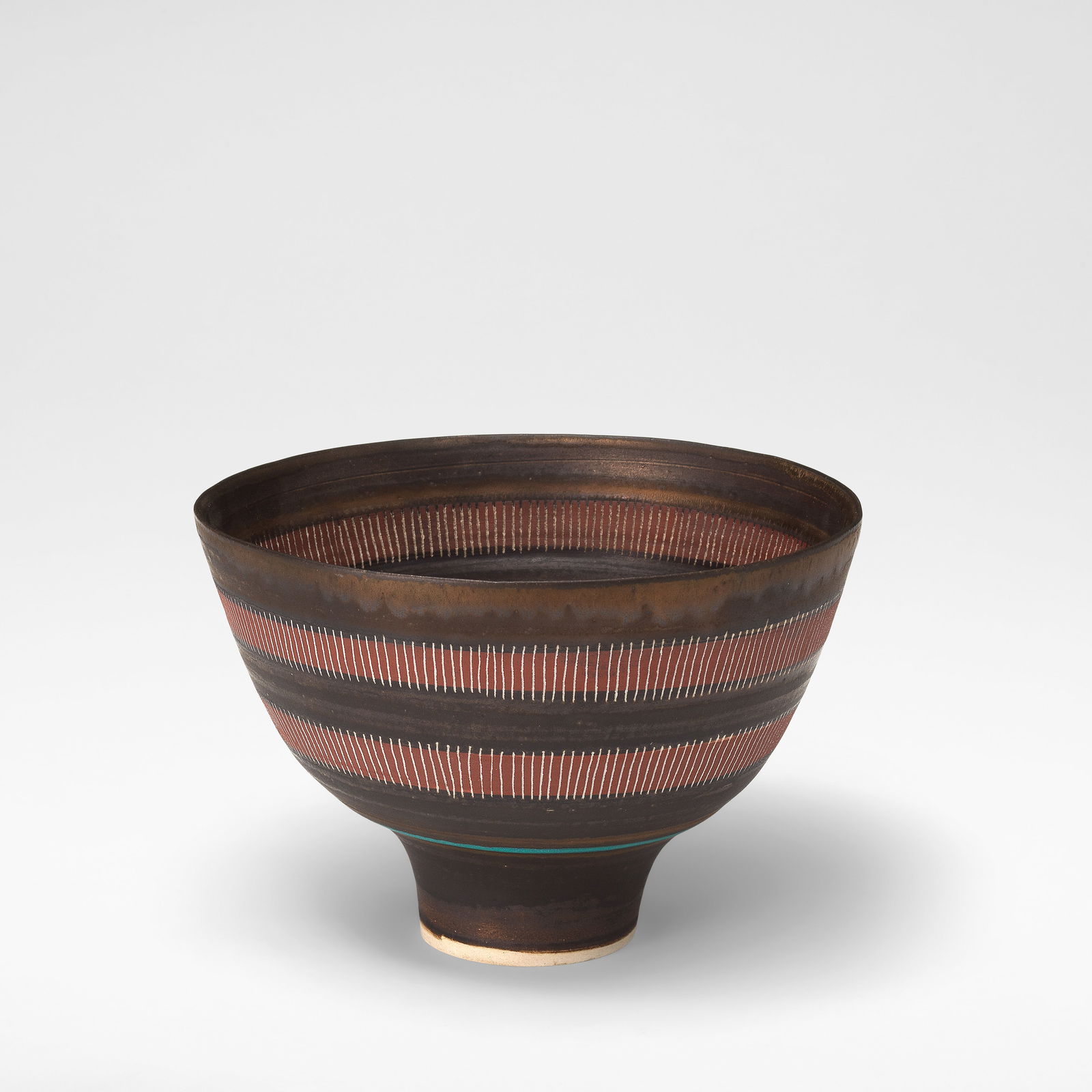 Lucie Rie Footed bowl, circa 1978: Lucie Rie Footed bowl, circa 1978 Porcelain, with terracotta, turquoise and golden manganese banding. Two bands of vertical sgraffito lines to interior and exterior. 12 cm high, 18 cm diameter Undersi