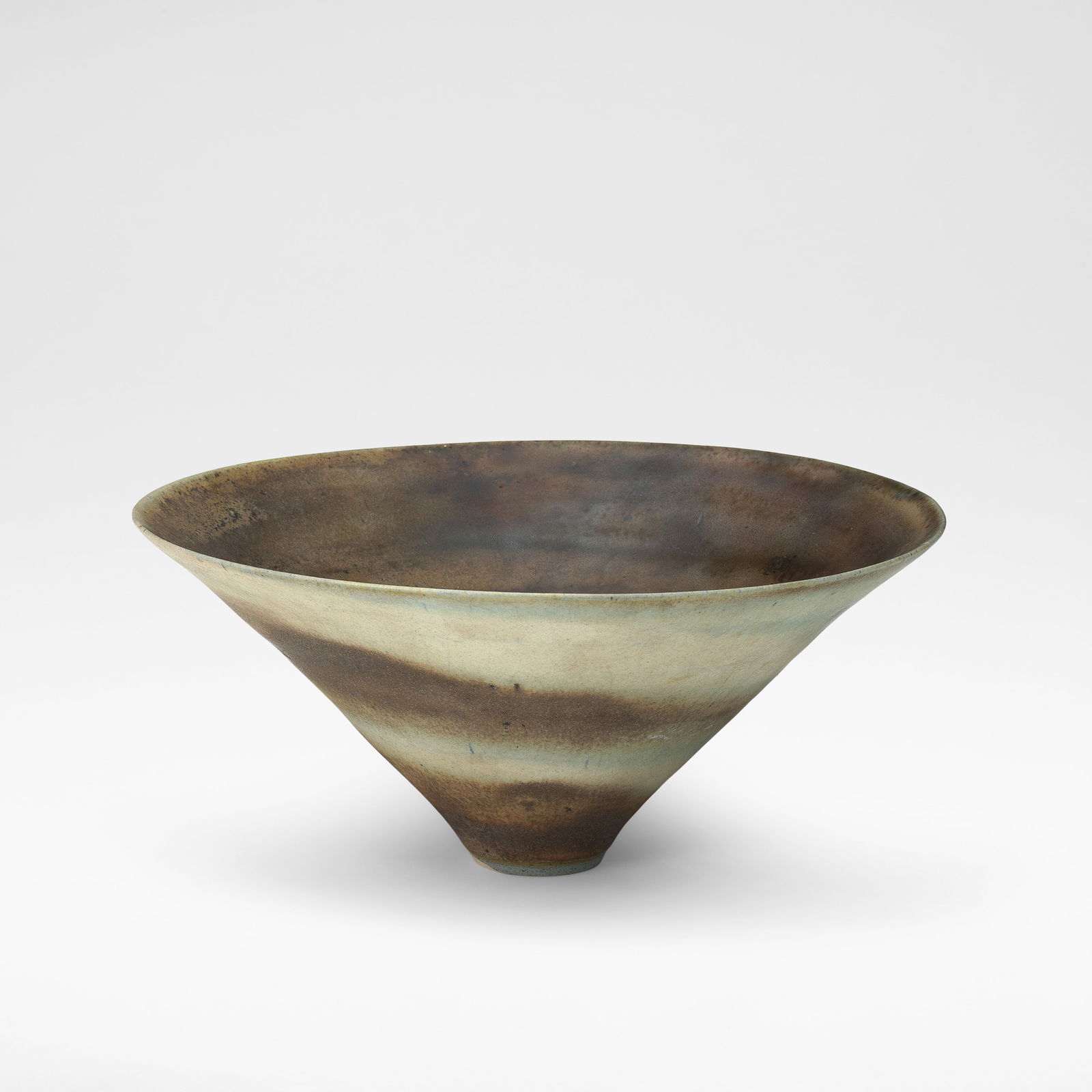 Lucie Rie Conical bowl, circa 1969: Lucie Rie Conical bowl, circa 1969 Porcelain, mixed clays producing an integral spiral in the glaze in pale blue, green, cream and brown colours. 11.7 cm high, 26 cm diameter Underside impressed with