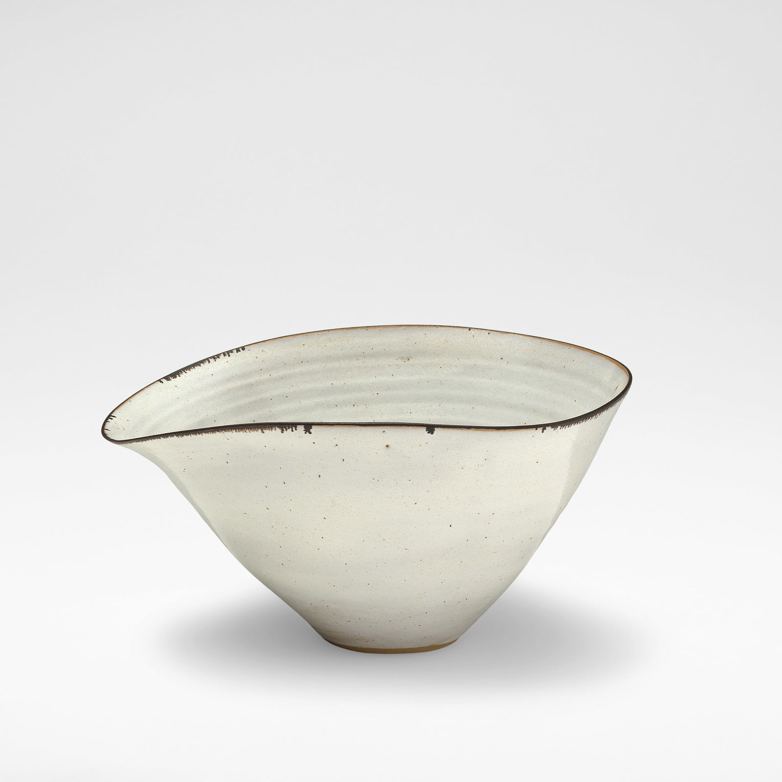 Lucie Rie Bowl with pouring lip, circa 1959: Lucie Rie Bowl with pouring lip, circa 1959 Stoneware, white glaze with feathered manganese rim. 11.5 cm high, 19.6 cm wide, 22.5 cm deep Underside impressed with artist's seal. Footnotes: Literature