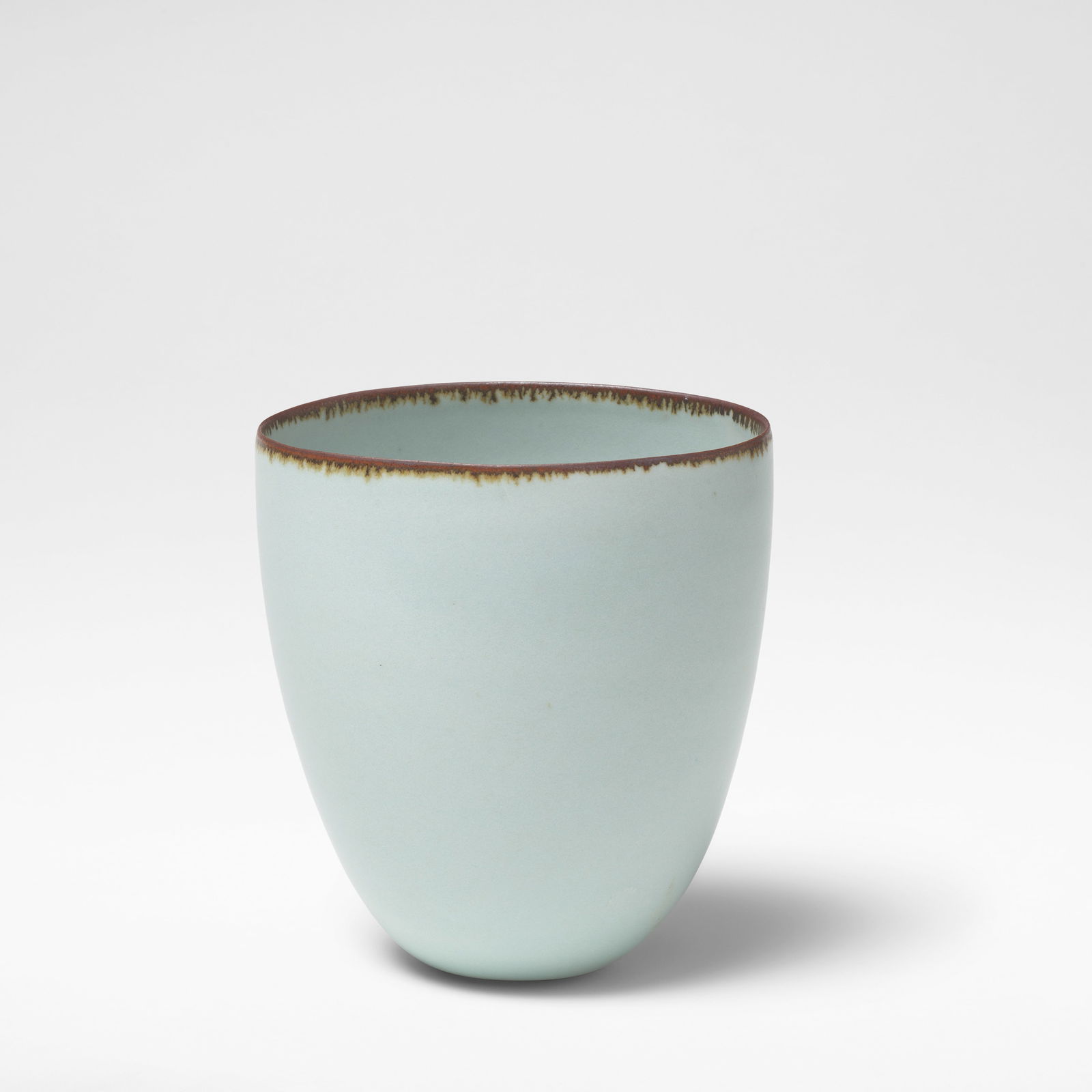 Joanna Constantinidis Vase, circa 1980: Joanna Constantinidis Vase, circa 1980 Porcelain, pale blue celadon glaze with iron feathered rim. 12.5 cm high, 11.2 cm wide, 9.5 cm deep Base impressed with artist's seal. This lot is subject to the