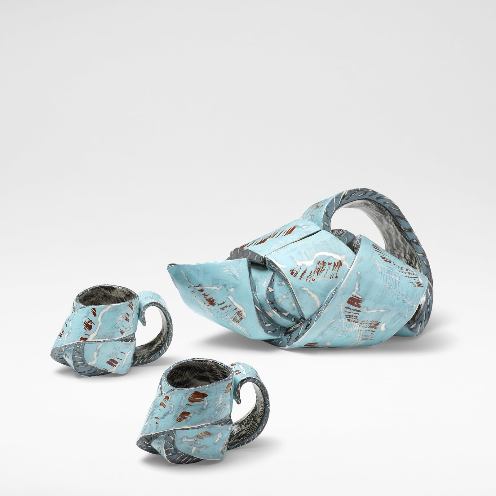 Carol McNicoll Teapot and two cups, circa 1987: Carol McNicoll Teapot and two cups, circa 1987 Slipcast earthenware, decorated in blue slip with white and red splashes. The tea pot: 18 cm high, 32 cm wide, 20 cm deep The cups: 8.5 cm high, 13 cm wi