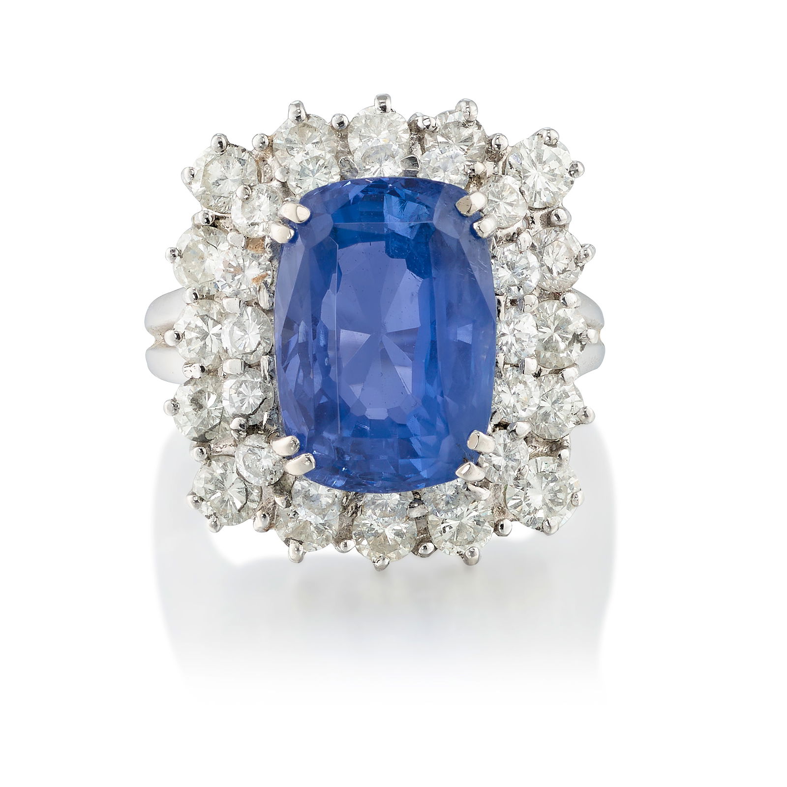 A SAPPHIRE AND DIAMOND RING: A SAPPHIRE AND DIAMOND RING Centering a cushion-shaped sapphire, in a double surround of round brilliant-cut diamonds; estimated sapphire weight 7.10 carats; estimated total diamond weight 1.90 carat