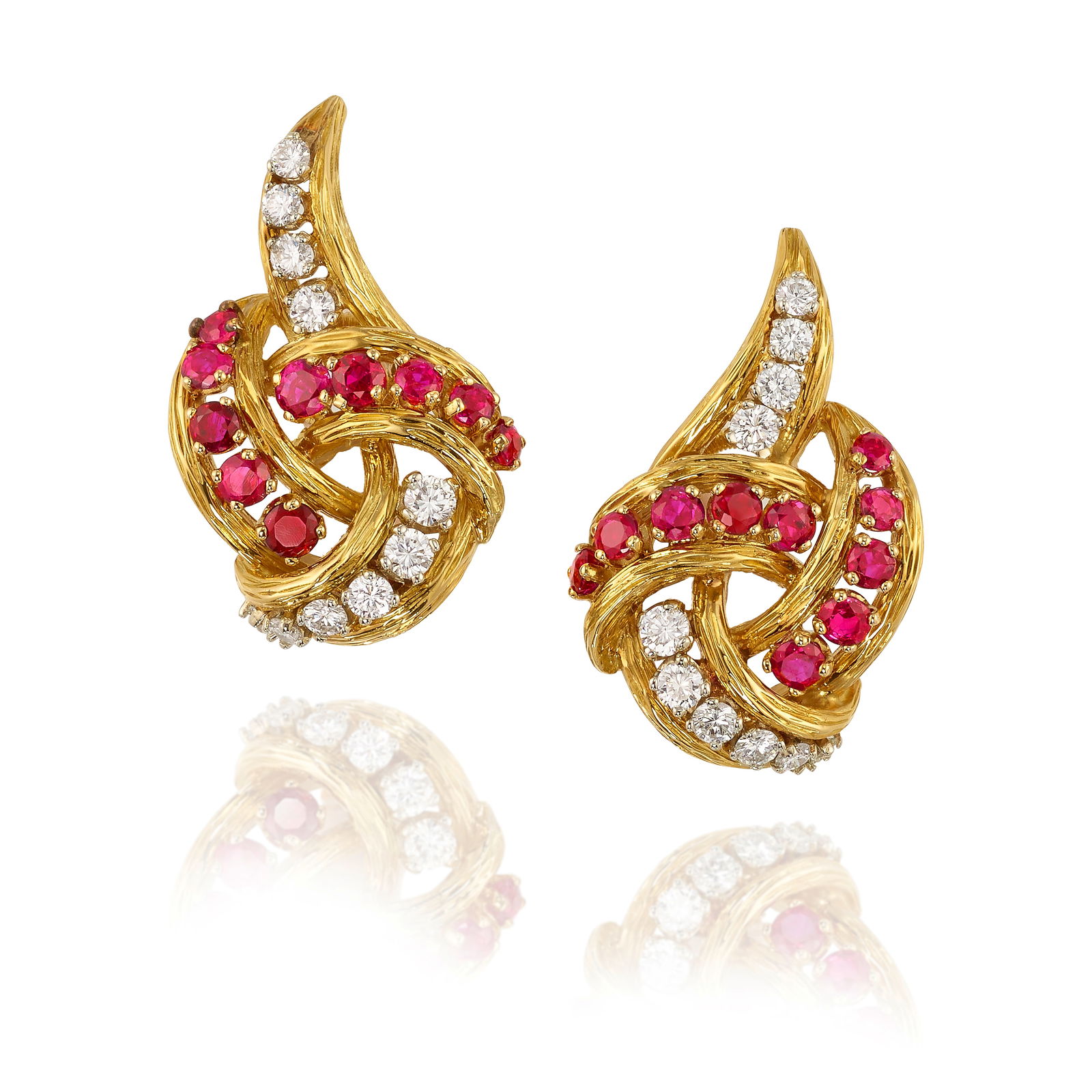 A PAIR OF 18K GOLD, RUBY AND DIAMOND EARCLIPS: A PAIR OF 18K GOLD, RUBY AND DIAMOND EARCLIPSEach of knotted design, set with round rubies, accented with round brilliant-cut diamonds; with maker's mark; with serial number; France; estimated total