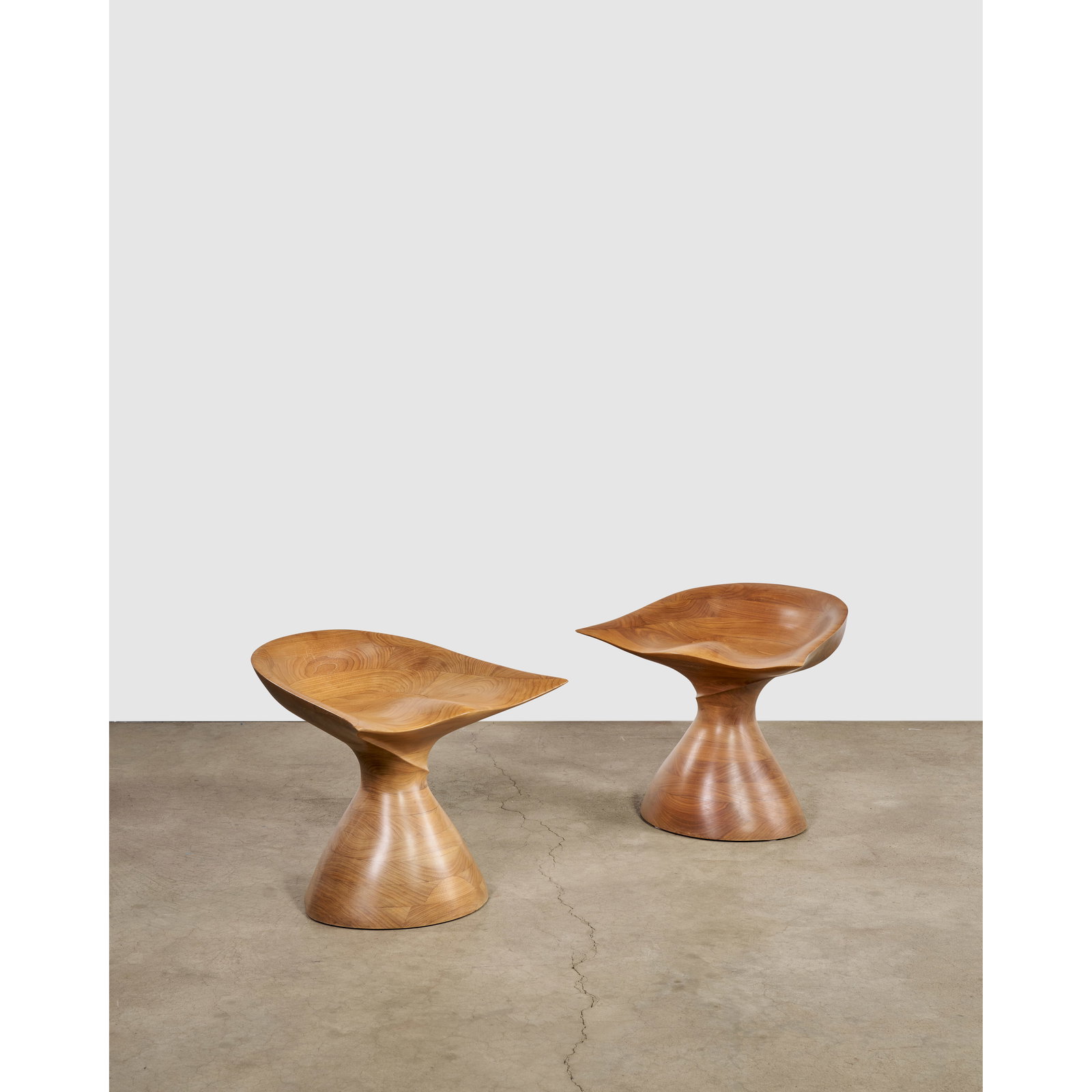 MICHAEL COFFEY (1928-2024) Rare Pair of 'Belle of the Ball' Stools circa 1970hand-carved walnut,...: MICHAEL COFFEY (1928-2024) Rare Pair of 'Belle of the Ball' Stools circa 1970 hand-carved walnut, engraved 'M. Coffey', numbered '10' and '12' height 22 1/4in (56.5cm); depth 21 1/2in (54.6cm); width