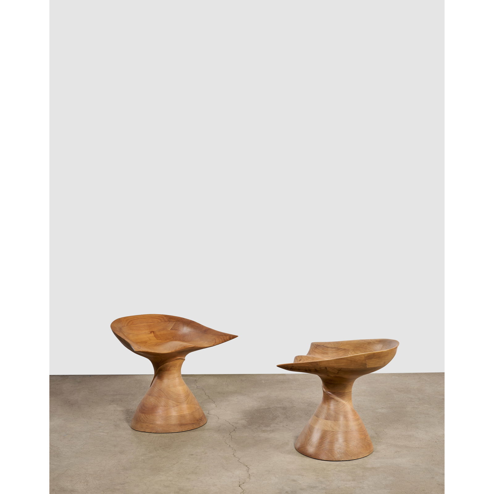 MICHAEL COFFEY (1928-2024) Rare Pair of 'Belle of the Ball' Stools circa 1970hand-carved walnut,...: MICHAEL COFFEY (1928-2024) Rare Pair of 'Belle of the Ball' Stools circa 1970 hand-carved walnut, engraved 'M. Coffey', numbered '7' and '9' height 22 1/4in (56.5cm); depth 21 1/2in (54.6cm); width 26