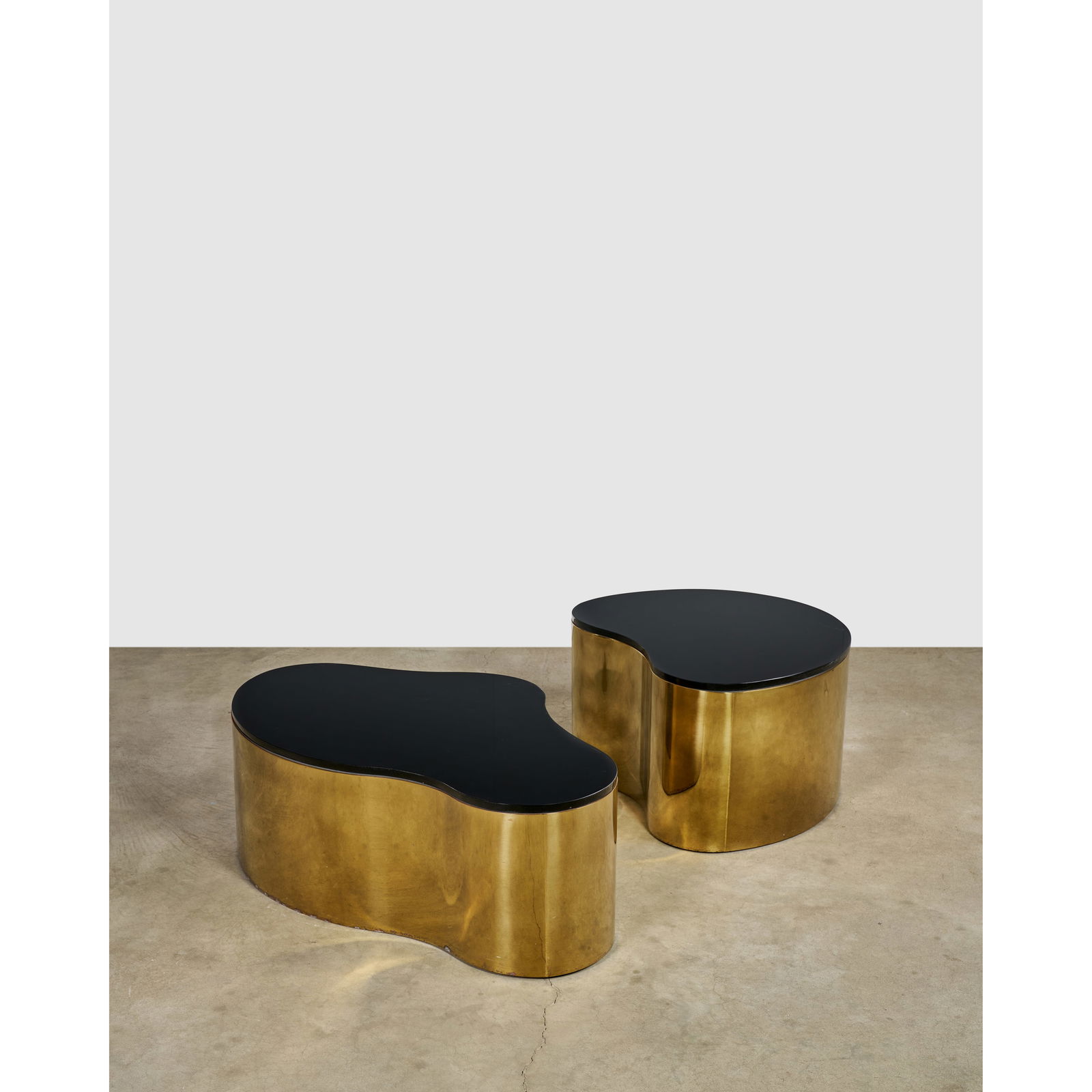 KARL SPRINGER (1931-1991) Pair of 'Freeform' Coffee Tablescirca 1980polished brass and glassheig...: KARL SPRINGER (1931-1991) Pair of 'Freeform' Coffee Tables circa 1980 polished brass and glass height of larger 16 1/2in (40.6cm); width 28 1/2in (72.4cm); length 45in (114.3cm) height of smaller 18 1
