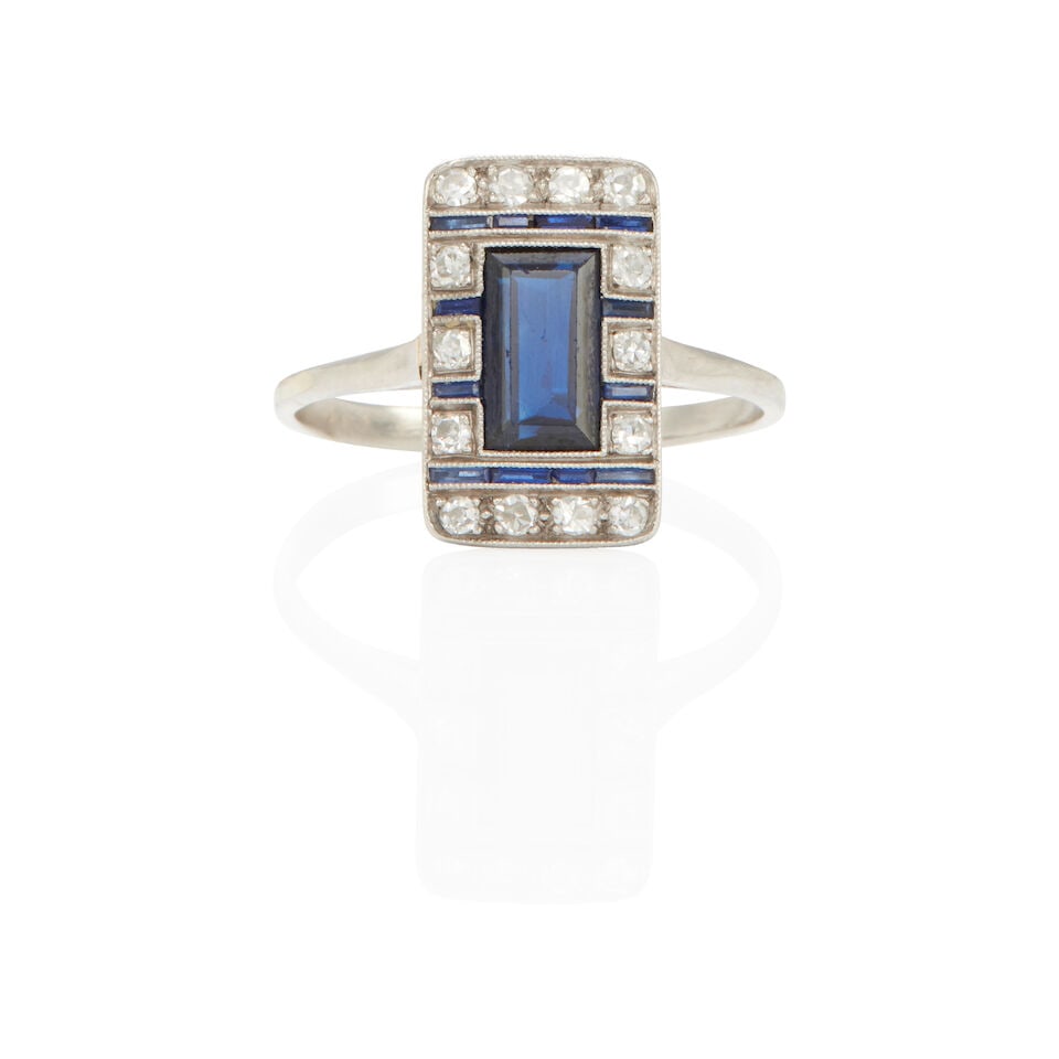 ART DECO PLATINUM, DIAMOND AND SAPPHIRE RING: ART DECO PLATINUM, DIAMOND AND SAPPHIRE RING • Platinum • 14 round diamonds weighing approximately 0.10 - 0.20 carat total • 1 rectangular center sapphire and numerous accent