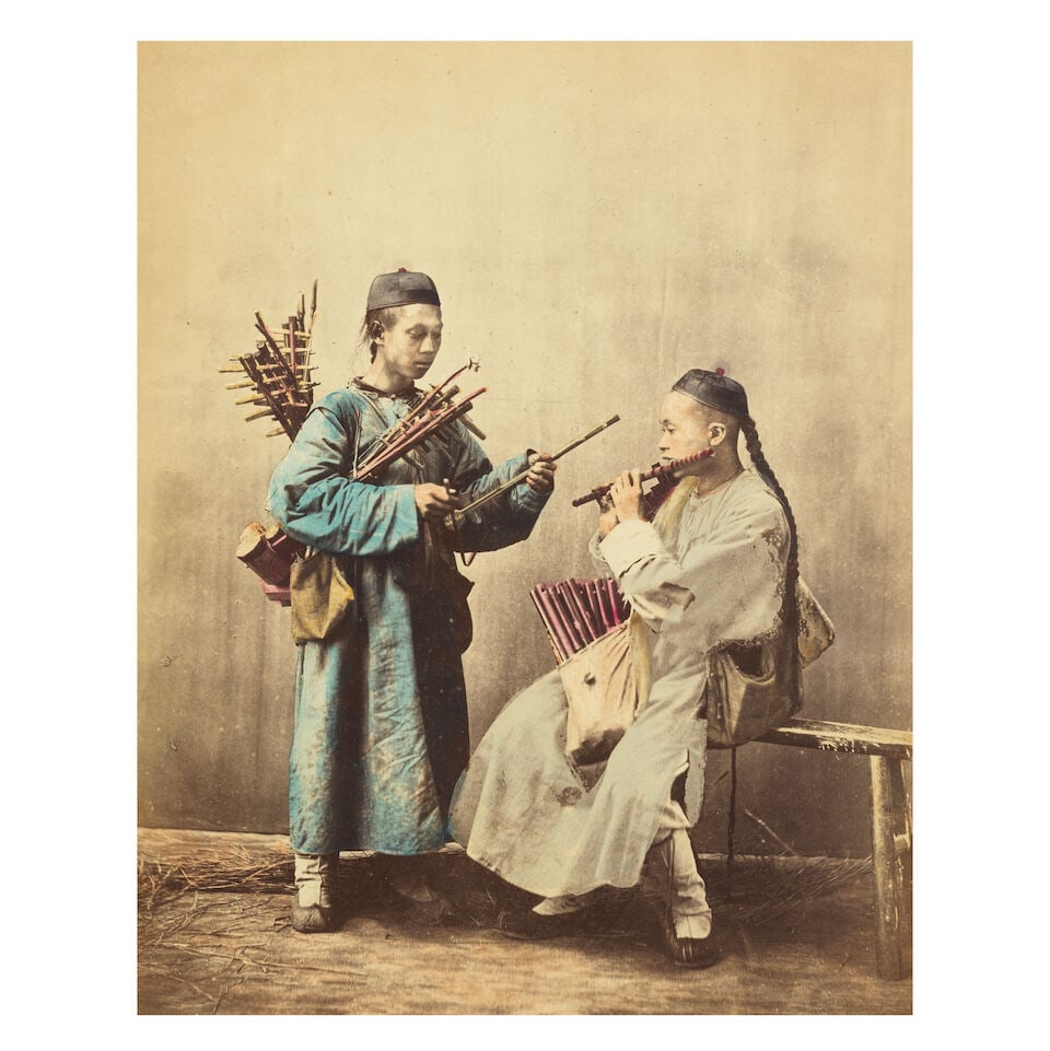 CHINA SAUNDERS (WILLIAM) Studio portrait of two musicians, [c.1870]; and another of two blind mu...: CHINA SAUNDERS (WILLIAM) Studio portrait of two musicians, hand-tinted albumen print, mounted on original sheet with printed caption 'No. 28 - 'Music for the Million', image 245 x 200mm., sheet 365 x 