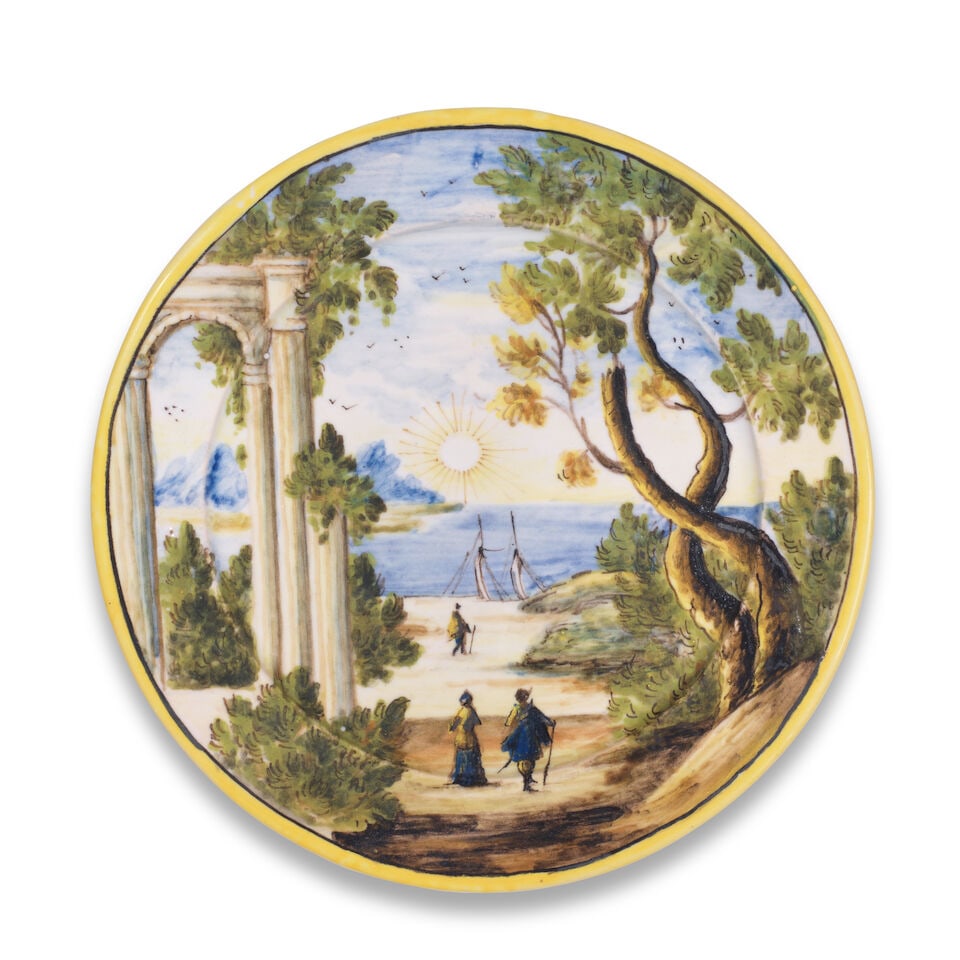 A small Castelli type maiolica plate, 19th century: A small Castelli type maiolica plate, 19th century Decorated with a coastal landscape scene, the rim edged in yellow, 18.5cm diam., mark in blue For further information on this lot please visit
