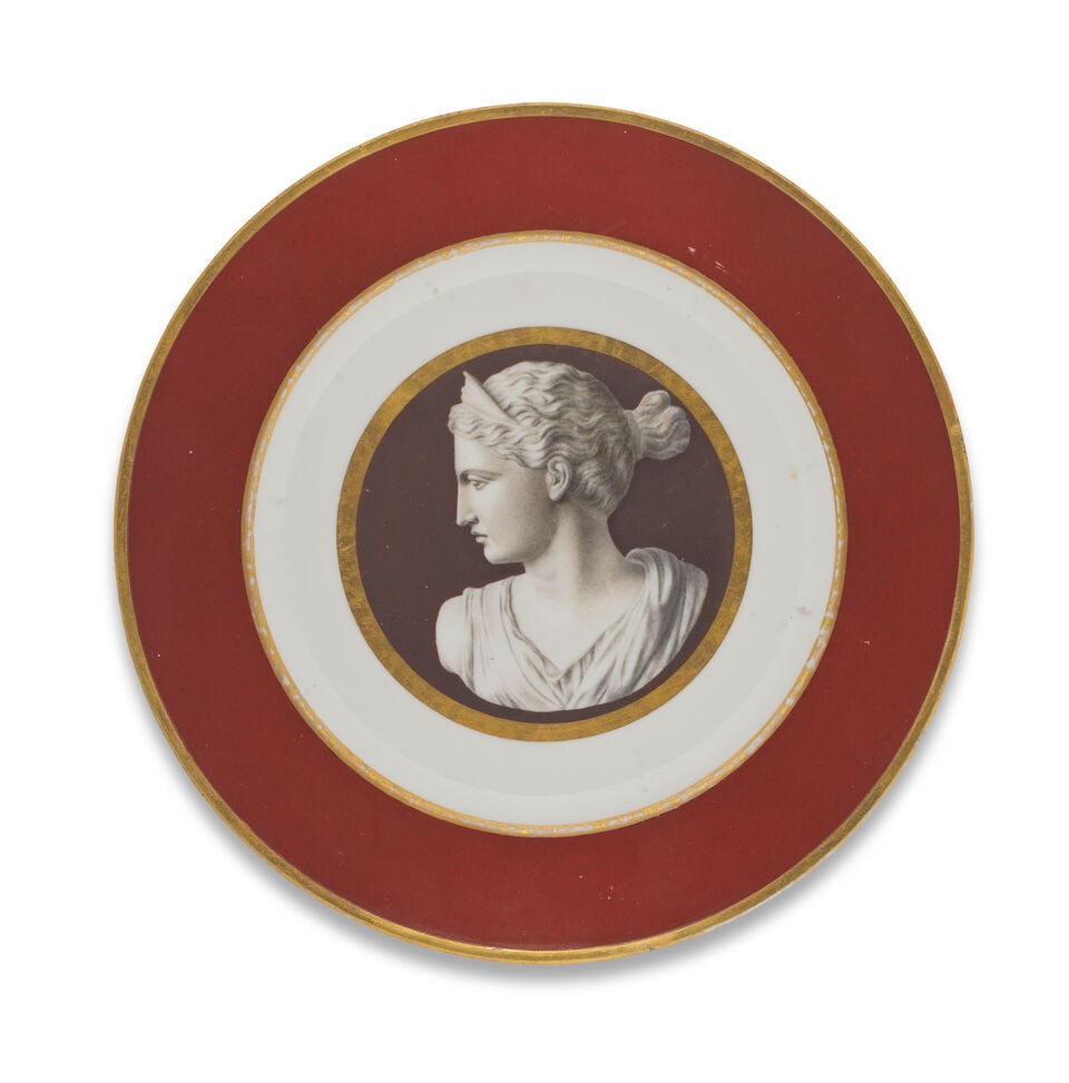 A later-decorated Sèvres plate with cameo centre, late 19th century: A later-decorated Sèvres plate with cameo centre, late 19th century Decorated with a plain red border outlined in gilding, the centre with a simple gold band enclosing a finely painted cameo en