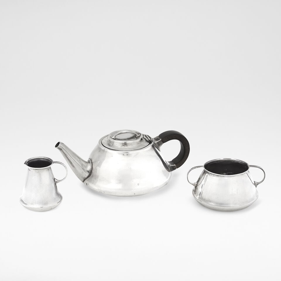 Liberty & Co. Three-piece tea service, 1909: Liberty & Co. Three-piece tea service, 1909 Silver, comprising; teapot, sugar bowl and milk jug, the teapot with an ebonized wooden handle. Teapot: 7 cm high, 17.5 cm wide, 12 cm deep Each underside s